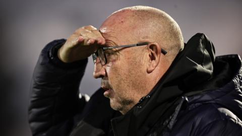 Aldershot Town boss John Coleman looks ahead with hand shielding eyes