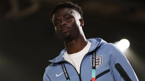 Bukayo Saka in a pale blue England tracksuit