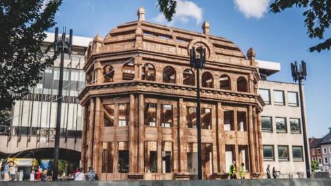 An artist's impression of a cardboard cathedral structure in a city centre.