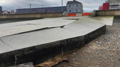 Damage to the Dundas Street slipway in Redcar. There are concrete slabs which have broken and are facing up at awkward angles on the side leading into the sea. 