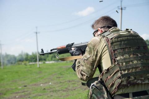 A foreign volunteer fighter who is not Craig Austin Lang holds a gun in Donetsk in 2015