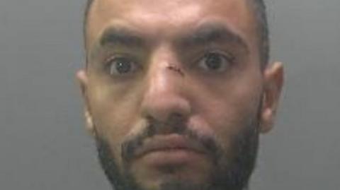 A custody photo of a man with a cut on his nose