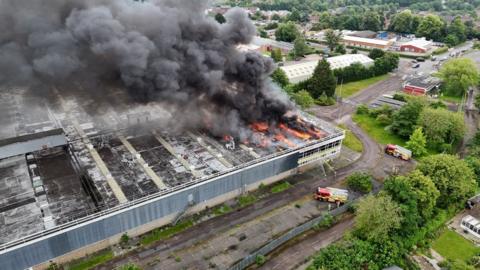 A fire in a large disused building with two fire engines outside 