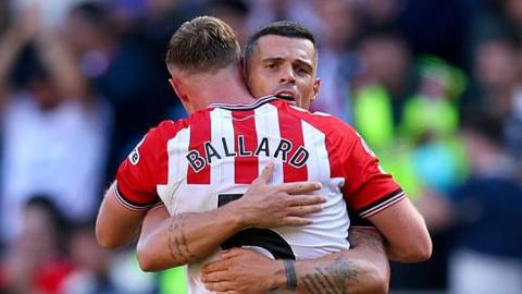 Dan Ballard hugs team-mate Granit Xhaka on the pitch