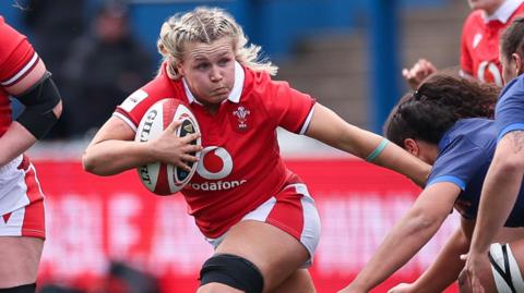 Alex Callender fending off a tackle against France