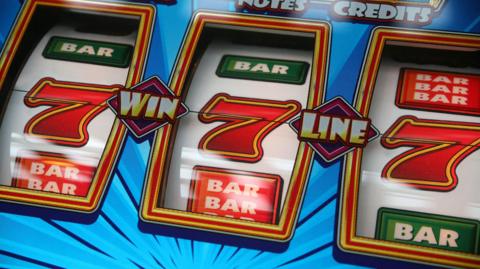 A gambling machine showing three number 7s in a row. 
