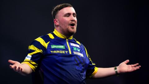 Luke Littler celebrates winning a set against Rob Cross