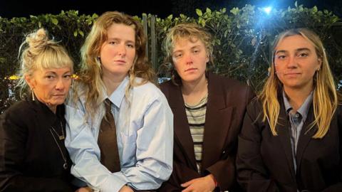 Four women, all looking at camera