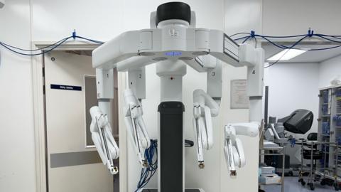 A white robot with four arms in an operating theatre