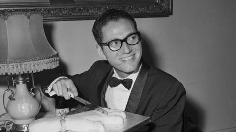 Tom Lehrer pictured cutting a cake in 1959