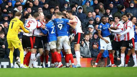 Players from Southampton and Portsmouth confront eachother after a heavy challenge in the game