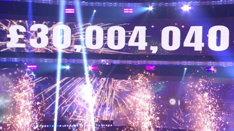 £30,004,040 on a big screen with pyrotechnics.