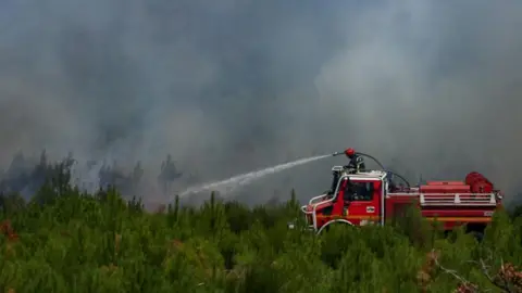 Firefighters work to extinguish flames at Le Grand Crohot.