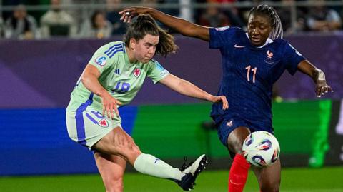 Esther Morgan of Wales (L) defends the ball from Kadidiatou Diani of France