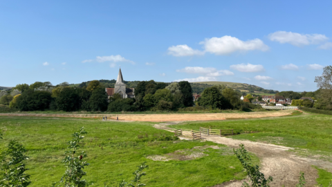 The repaired riverbank just outside Alfriston with the village church in the background