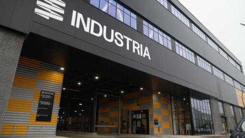 Exterior view of the multi-storey Industria warehouse development with the name “Industria” displayed on the building’s façade.