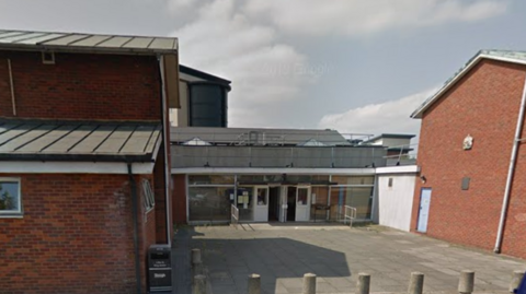 Slough County Court is a glass-fronted building at the back of a paved area protected by bollards