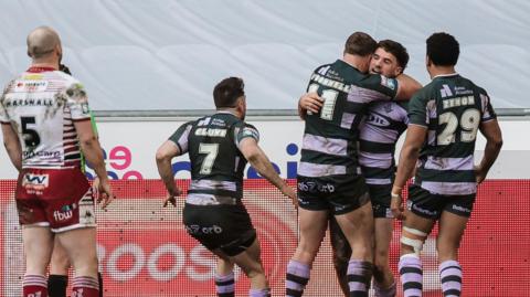 Connor Wrench (right) is mobbed by three team-mates after scoring a try as Liam Marshall (MARSHALL- 5) looks on 
