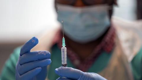  a pharmacist preparing the vaccine in a pop-up vaccination clinic