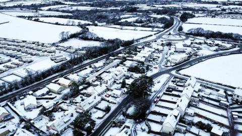 Aerial view of Pembrokeshire houses and caravans with snowy fields