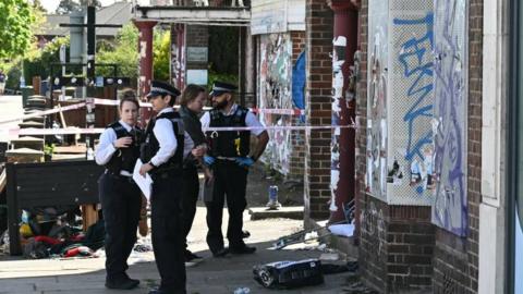 Four police officials stand outside a building 