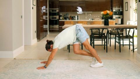 Joe Wickes stretches with his hands on the floor