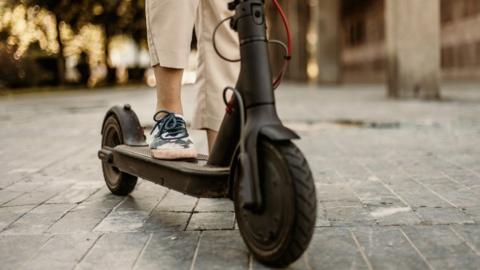 A stock closeup of a person on an e-scooter 