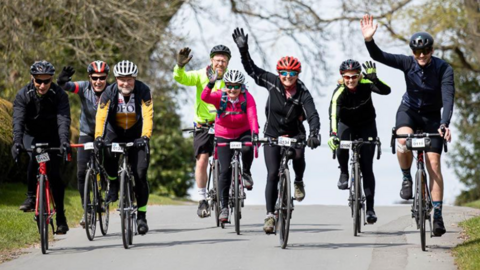 Group of cyclists waving