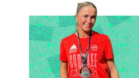 Woman wearing a red t-shirt with a medal round her neck