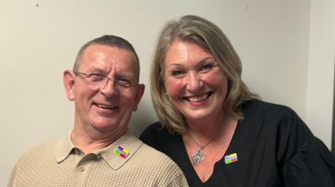 Martin Murtagh who took part in the collaboration wearing a beige top and glasses alongside Karen Kerr from Dementia NI wearing a black dress