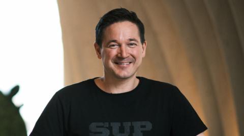 Ilkka Paananen smiling and wearing a black t-shirt