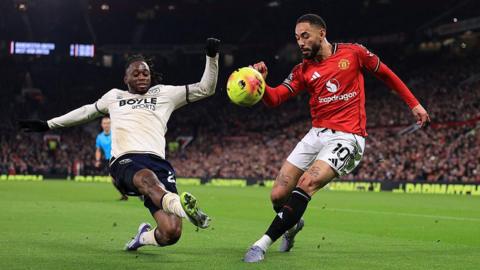 Aaron Wan-Bissaka and Matheus Cunha compete for the ball