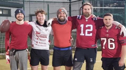 The Teesside Thunder team are arm-in-arm ahead of one of their first friendly matches. They are smiling and four of five are wearing red tops.