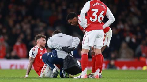 Ben White receives treatment on the pitch.