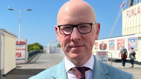 Patrick Hurley, wearing glasses and a blue jacket