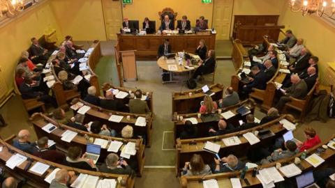 A birds eye view of a council chamber in a semi-circle shape