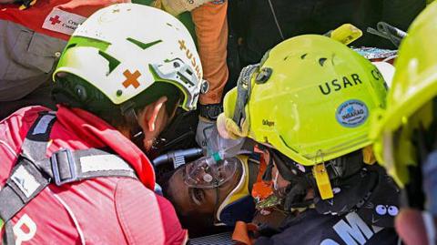 An international rescue team assists Hernan Gil, a survivor of Venezuela's twin earthquakes, in Catia La Mar, La Guaira State, Venezuela on July 2, 2026, eight days after the quake.