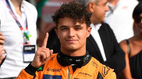 McLaren's Lando Norris holds up his right index finger in celebration