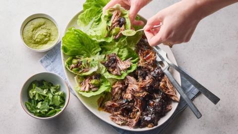 Pulled lamb on a plate with pieces of lettuce