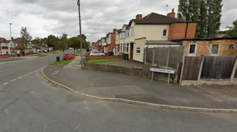 A road junction, with the end of one street at the bottom of the image and another road meeting it on the left of the photo.
