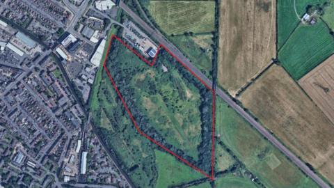 An aerial photograph of a field in Loughborough with a red line around it. 