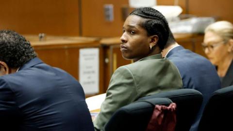 A$AP Rocky seated at a table with attorneys in a LA courtroom as his trial continues. 