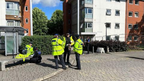 Police officers stood outside a university building. 