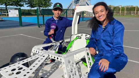 Child contributor Arun and Nina Blissett sitting with an electric car between them.