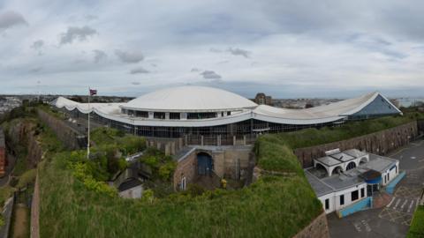 Image of Fort Regent. A large white building domed building.