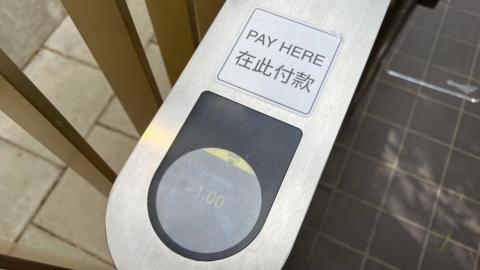A view of the silver payment tower from above. It says "Pay Here", with Chinese writing underneath.