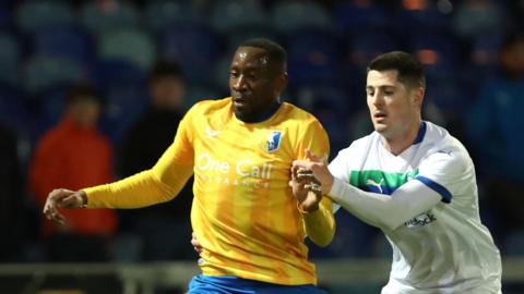 Lucas Akins (left) in action for Mansfield Town against Wigan on Tuesday