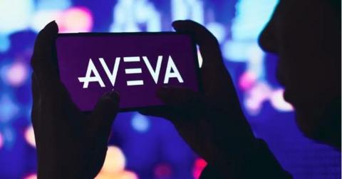 A silhouette of a person holding a phone with the Aveva logo on it