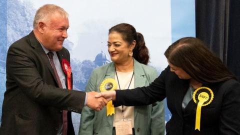 cottish Labour's Davy Russell shakes hands with SNP candidate Katy Loudon (right)