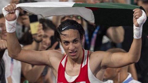 Imane Khelif holding up the Algerian flag after winning Olympic gold